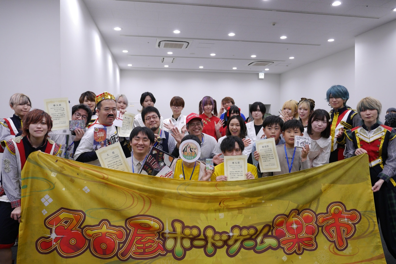楽市ドラゴン大賞の授賞式。受賞者が賞状を手に、名古屋ボードゲーム楽市の横断幕を囲んでいる